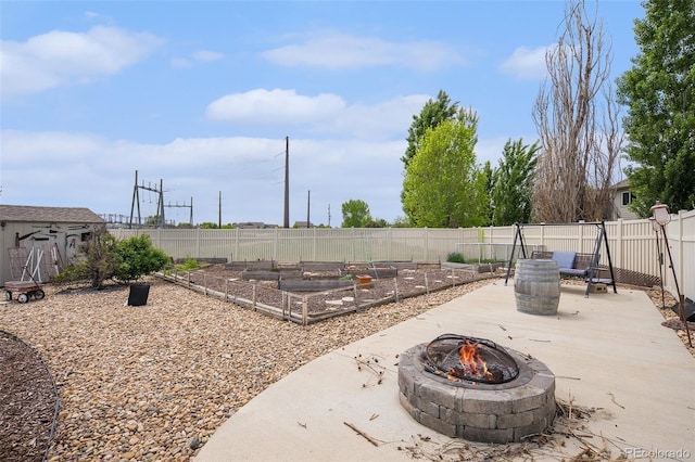 9650 Raven St, Firestone, CO 80504 - fenced backyard featuring an outdoor fire pit, a vegetable garden, and a patio area