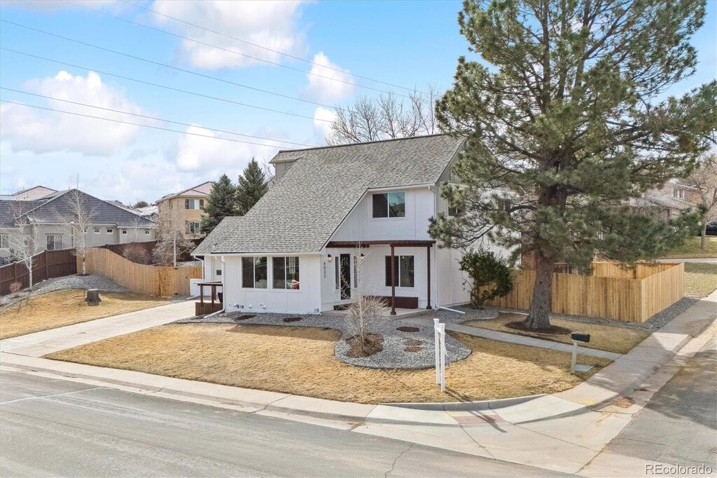 view of front of house with a shingled roof and fence