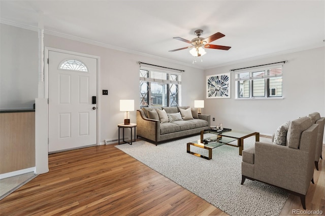 living area featuring ornamental molding, a ceiling fan, plenty of natural light, and wood finished floors