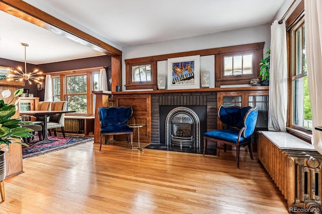 3145 W 31st Ave, Denver, CO 80211 - sitting room with a chandelier, wood finished floors, a brick fireplace, and beamed ceiling