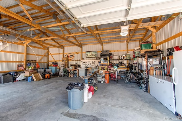 garage featuring white refrigerator and a workshop area