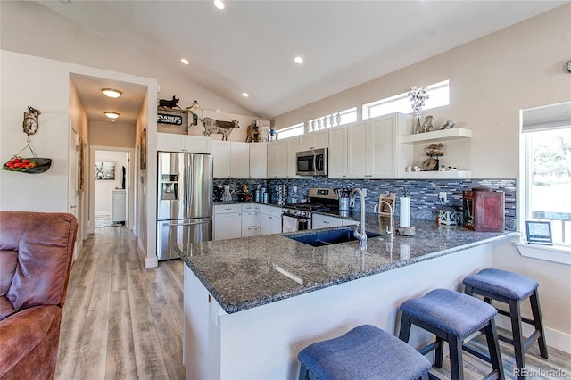 18050 Wedemeyer Rd, Kiowa, CO 80117 - kitchen featuring stainless steel appliances, a peninsula, dark stone countertops, open shelves, and tasteful backsplash