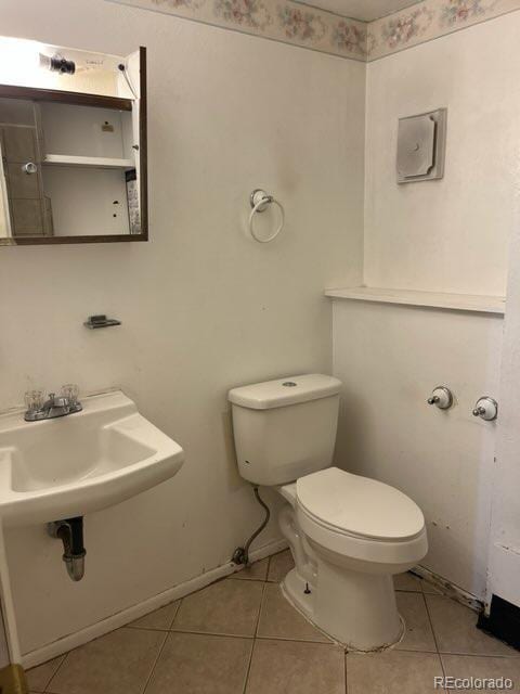 11318 Clermont Dr, Thornton, CO 80233 - half bathroom featuring tile patterned floors, toilet, and a sink