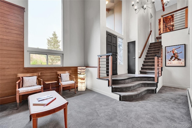 30334 Roan Dr, Evergreen, CO 80439 - living area with stairway, a towering ceiling, carpet flooring, a chandelier, and wooden walls