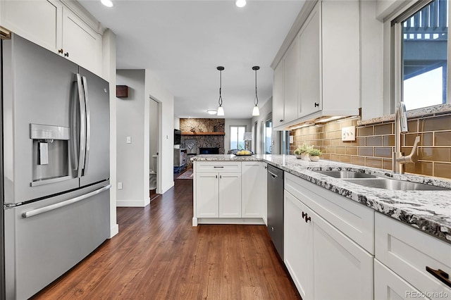 30334 Roan Dr, Evergreen, CO 80439 - kitchen with stainless steel appliances, tasteful backsplash, a peninsula, white cabinetry, and recessed lighting