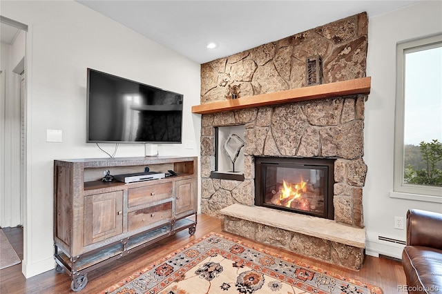 30334 Roan Dr, Evergreen, CO 80439 - living area with wood finished floors, a baseboard radiator, and a fireplace