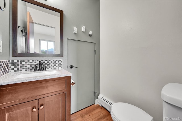 30334 Roan Dr, Evergreen, CO 80439 - half bathroom with a baseboard radiator, vanity, tasteful backsplash, and wood finished floors