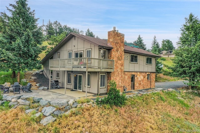 30334 Roan Dr, Evergreen, CO 80439 - back of house featuring an outdoor fire pit, a chimney, a patio, stone siding, and stairs