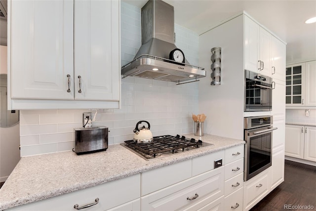 6666 S Pennsylvania St, Centennial, CO 80121 - kitchen featuring wall chimney exhaust hood, appliances with stainless steel finishes, tasteful backsplash, white cabinets, and dark wood-type flooring