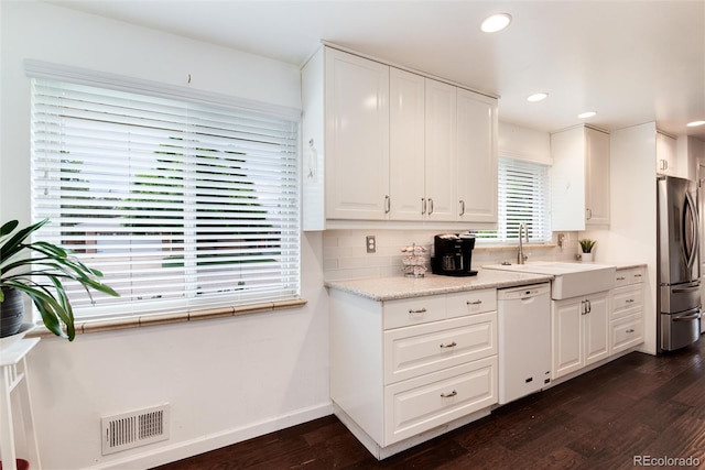 6666 S Pennsylvania St, Centennial, CO 80121 - kitchen with white dishwasher, freestanding refrigerator, dark wood finished floors, white cabinets, and tasteful backsplash
