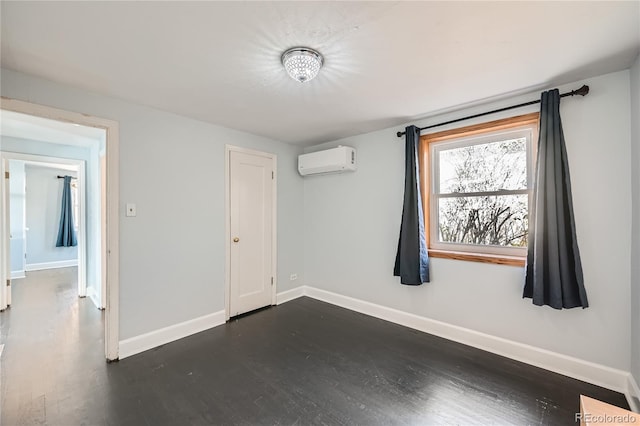 empty room with dark wood-type flooring and a wall mounted air conditioner