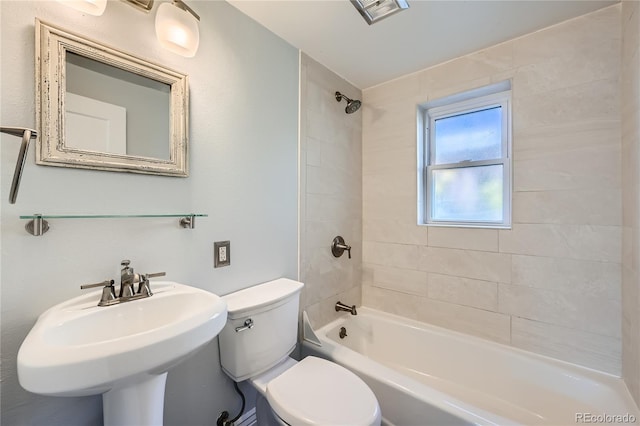 full bathroom featuring sink, tiled shower / bath, and toilet