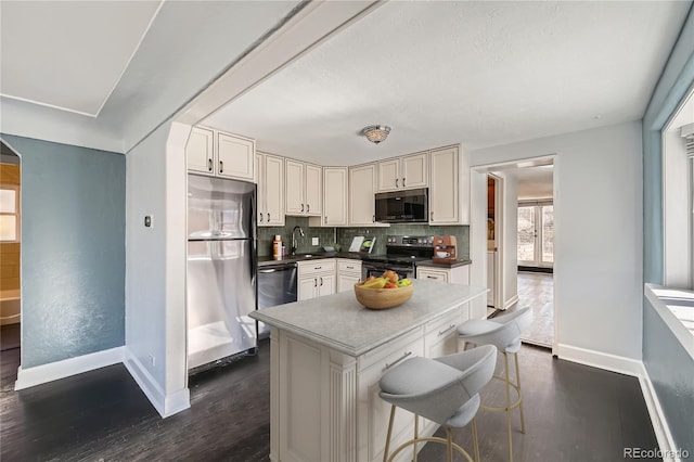 kitchen featuring white cabinets, stainless steel appliances, dark wood-type flooring, sink, and backsplash