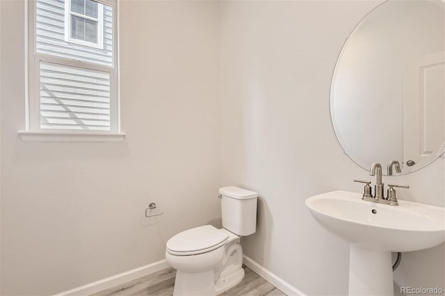 bathroom with hardwood / wood-style flooring, toilet, and sink