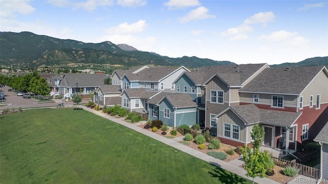 44 S Olympian Dr, Colorado Springs, CO 80905 - view of front of house with board and batten siding, a mountain view, a residential view, and a front lawn