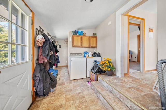 clothes washing area featuring cabinets and independent washer and dryer