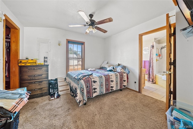 bedroom with carpet flooring, ensuite bathroom, vaulted ceiling, and ceiling fan