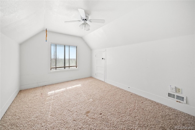 additional living space with carpet flooring, ceiling fan, a textured ceiling, and vaulted ceiling