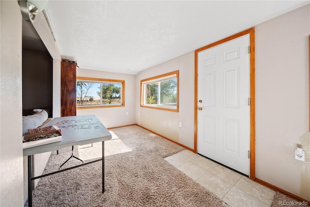 carpeted foyer entrance with a textured ceiling