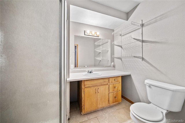 bathroom featuring tile patterned flooring, vanity, and toilet