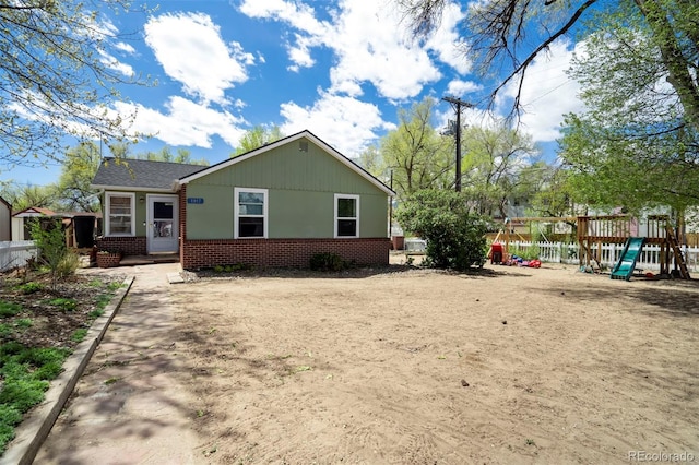 1917 E Cache La Poudre St, Colorado Springs, CO 80909 - view of side of property featuring brick siding, fence, and a playground