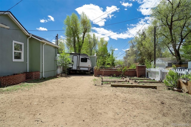 1917 E Cache La Poudre St, Colorado Springs, CO 80909 - view of yard featuring fence, a vegetable garden, and driveway