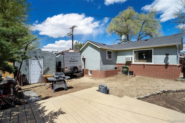 1917 E Cache La Poudre St, Colorado Springs, CO 80909 - rear view of house featuring brick siding, a shingled roof, stucco siding, and a wooden deck