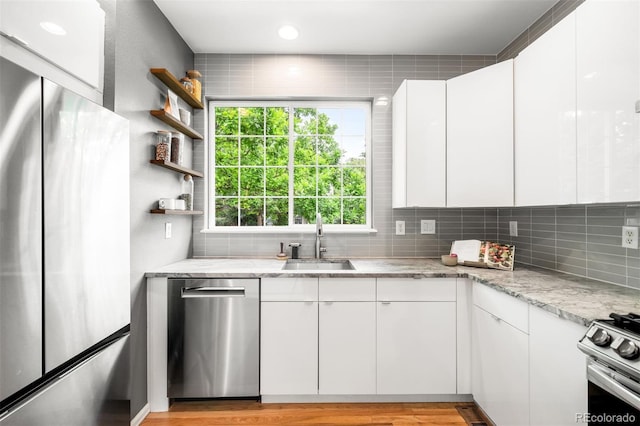 1947 King St, Denver, CO 80204 - kitchen featuring appliances with stainless steel finishes, a sink, backsplash, white cabinets, and open shelves
