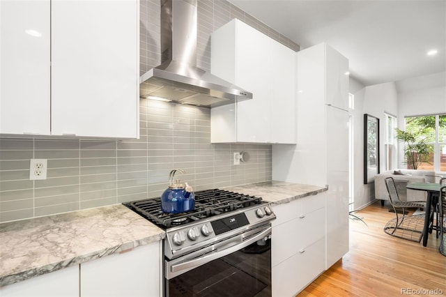 1947 King St, Denver, CO 80204 - kitchen featuring stainless steel gas range oven, wall chimney exhaust hood, modern cabinets, and light wood finished floors