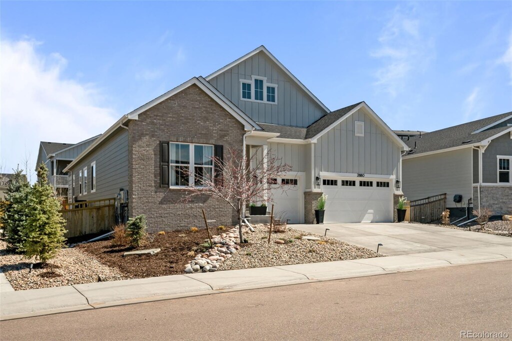2880 Keepsake Way, Castle Rock, CO 80109 - craftsman-style house featuring an attached garage, board and batten siding, driveway, and fence