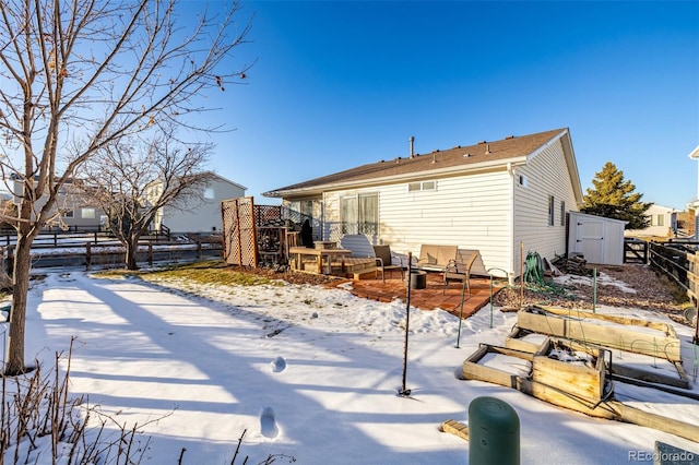 snow covered property featuring a storage unit and a fire pit