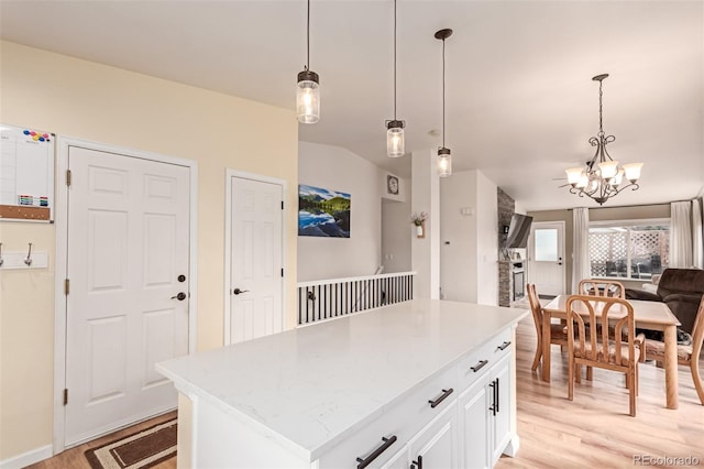 kitchen with pendant lighting, open floor plan, a center island, and light wood finished floors