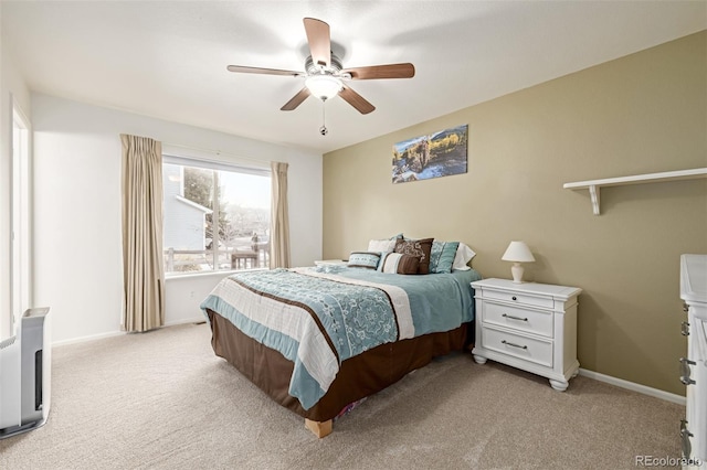 bedroom with a ceiling fan, baseboards, and light carpet