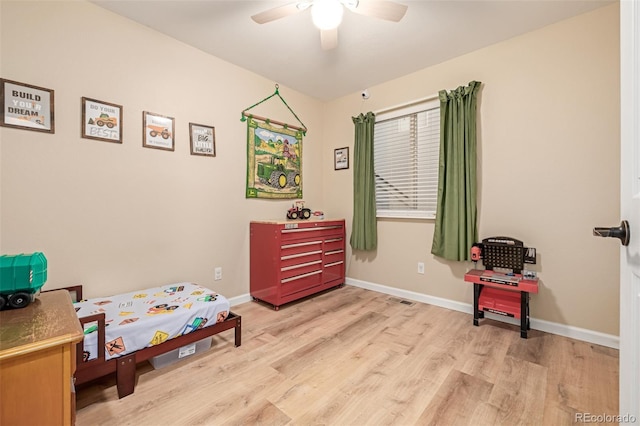 bedroom featuring wood finished floors, baseboards, and ceiling fan