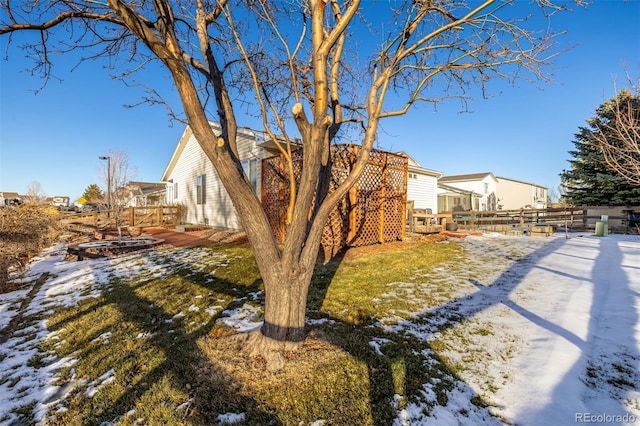 yard covered in snow featuring a deck and fence