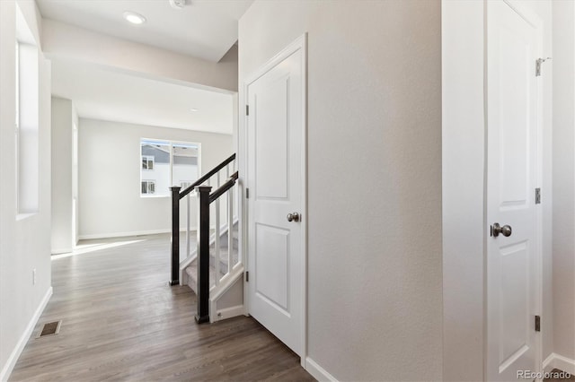 hall featuring stairway, wood finished floors, visible vents, and baseboards