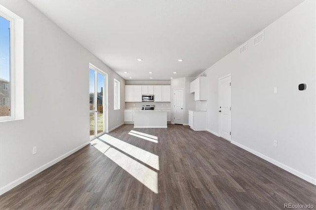 unfurnished living room featuring dark wood-style floors, recessed lighting, visible vents, and baseboards