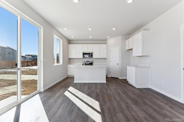 kitchen with baseboards, dark wood finished floors, appliances with stainless steel finishes, white cabinetry, and recessed lighting