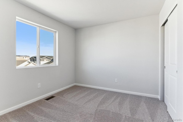 unfurnished bedroom with baseboards, a closet, visible vents, and carpet flooring