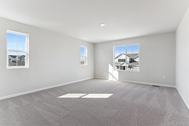 carpeted empty room with visible vents and baseboards