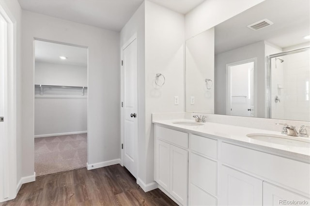 full bath featuring a walk in closet, a sink, visible vents, and a shower stall