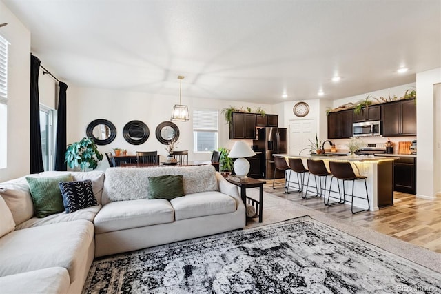 living room featuring a chandelier, recessed lighting, and light wood-style floors