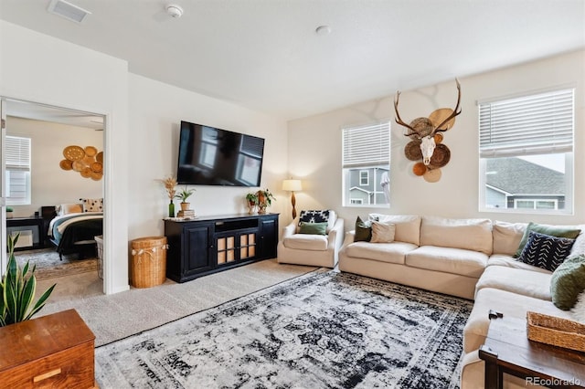 carpeted living room with a wealth of natural light and visible vents