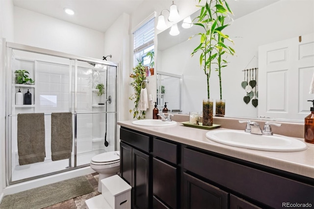 bathroom featuring a sink, toilet, and a shower stall