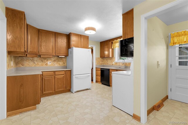 1091 E Pinewood Ave, Centennial, CO 80121 - kitchen with freestanding refrigerator, dishwasher, brown cabinetry, light countertops, and backsplash