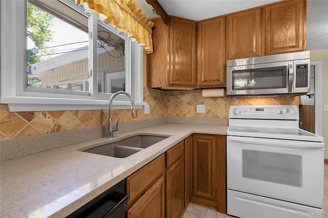 1091 E Pinewood Ave, Centennial, CO 80121 - kitchen with stainless steel microwave, white range with electric stovetop, brown cabinetry, backsplash, and dishwashing machine