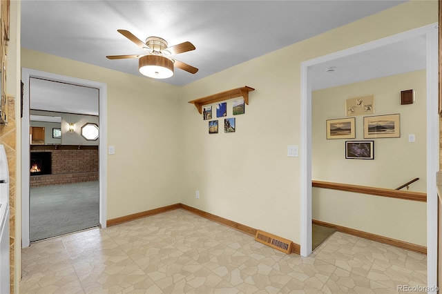 1091 E Pinewood Ave, Centennial, CO 80121 - unfurnished room featuring a ceiling fan and a brick fireplace