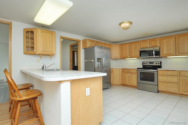 30870 County Road 356, Buena Vista, CO 81211 - kitchen with stainless steel appliances, a peninsula, a kitchen breakfast bar, light countertops, and glass insert cabinets