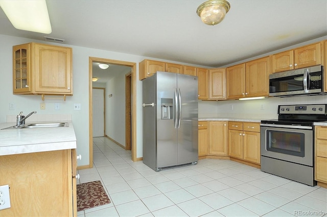 30870 County Road 356, Buena Vista, CO 81211 - kitchen with stainless steel appliances, light countertops, light tile patterned floors, light brown cabinets, and glass insert cabinets