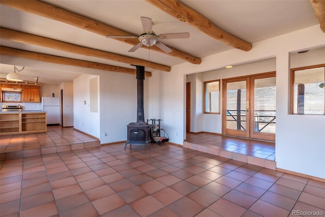 unfurnished living room featuring a wood stove, french doors, beam ceiling, and tile patterned floors